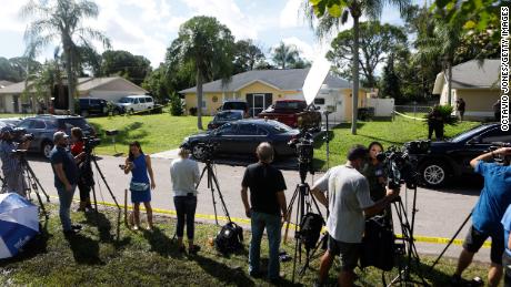 Members of the media wait near the Florida home of Brian Laundrie, who was named a person of interest after his fiancée Gabby Petito went missing in September 2021. The public remains fascinated by manhunts, and a few elements, such as a sense of an &quot;unfinished story,&quot; play a part.