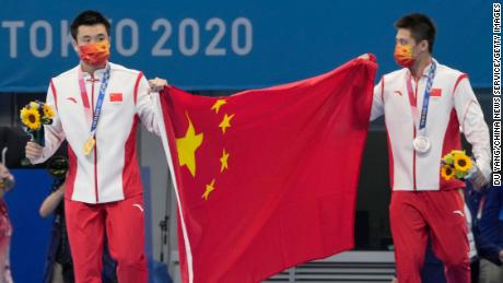 الصين تساو يوان (يسار) ويانغ جيان يحتفلان بميداليتهما في نهائي منصة العشرة أمتار رجال في أولمبياد طوكيو. 