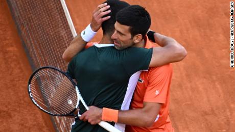 Alcaraz (L) and Djokovic embrace at the end of their ATP Tour Madrid Open 2022 semi-final.