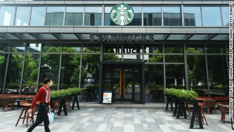 Nisan ayında Hangzhou'da kapalı bir Starbucks mağazasının yanında yürüyen bir yaya.