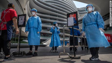 Health workers wear protective clothing at the entrance to the Coveid 19 testing site in a shopping complex in Beijing.