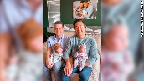 Chris (left) and Bryan Lambillotte pose with their newborn twins, Brecon and London.