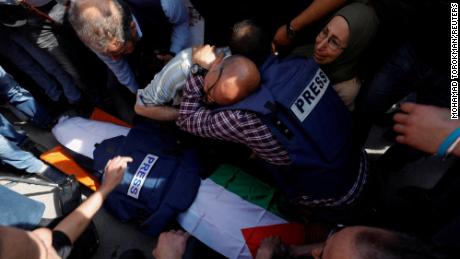 Mourners, including journalists, react next to the body of Al Jazeera reporter Shireen Abu Akleh.
