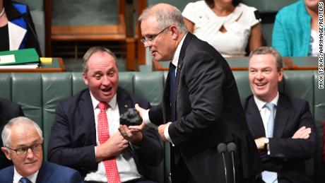 Then Treasurer Scott Morrison hands Deputy Prime Minister Barnaby Joyce a lump of coal during Question Time in Canberra on Feb. 9, 2017.