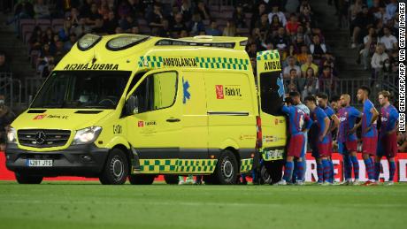 Barcelona&#39;s players look on as Ronald Araujo is transported off the field.