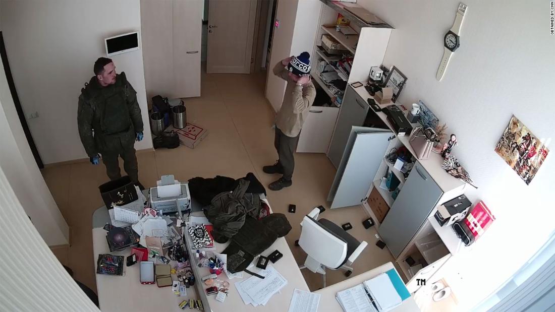 Russian soldiers scavenge and loot a business, in a scene from the security video.