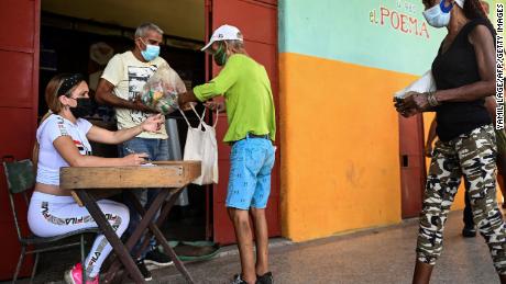 كوبيون يجمعون الطعام المتبرع به في سوبر ماركت في هافانا في أغسطس 2021. 
