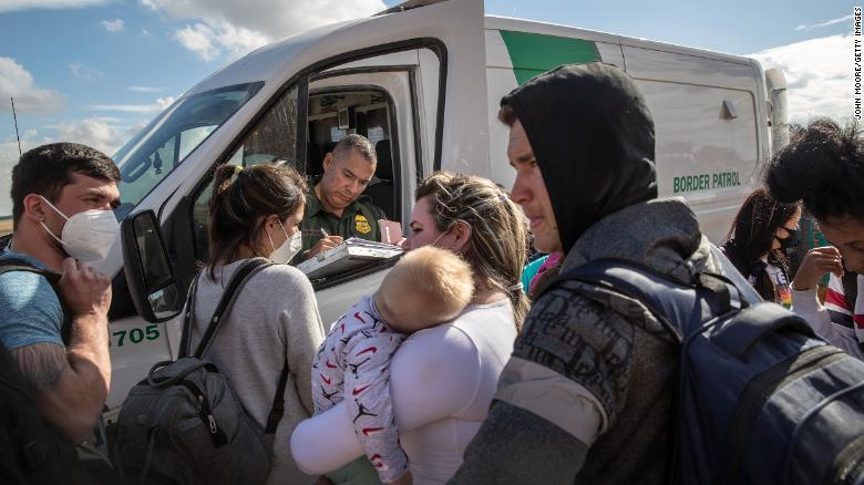 A family from Cuba waits to be transported to a US Border Patrol processing center in December 2021 in Yuma, Arizona.