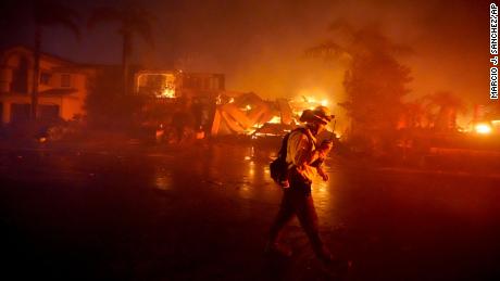 A firefighter works to put out flames during a wildfire in Laguna Niguel, California.