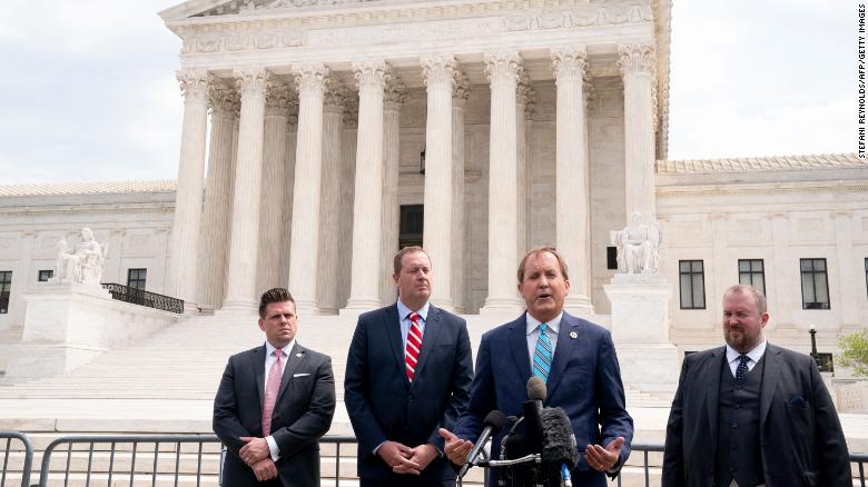 Texas Attorney General Ken Paxton (2R) and Missouri Attorney General Eric Schmitt (2L) speak to reporters in front of the US Supreme Court in Washington, DC, on April 26, 2022. 