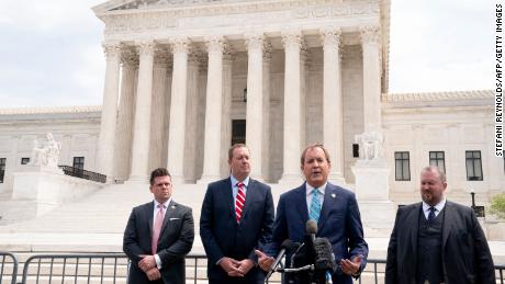 Texas Attorney General Ken Paxton (2 right) and Missouri Attorney General Eric Schmidt (2L) speak to reporters in front of the US Supreme Court in Washington, D.C., on April 26, 2022. 