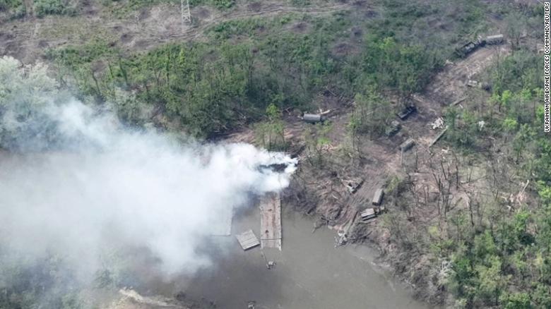 Smoke rises from what appears to be a makeshift bridge across the Siverskyi Donets River in a handout image from Ukrainian Airborne Forces Command, provided on May 12, 2022.