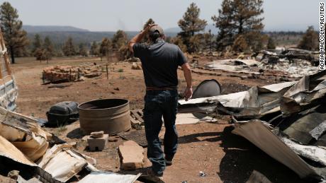 Michael Salazar walks through his property that burned down during the Hermits Peak and Calf Canyon fires in Tierra Monte, New Mexico.