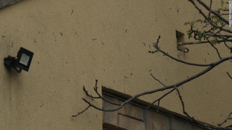 这张于 5 月 13 日星期五拍摄的照片显示，箭弹射弹卡在 Irpin 的另一个平民住宅的墙上。