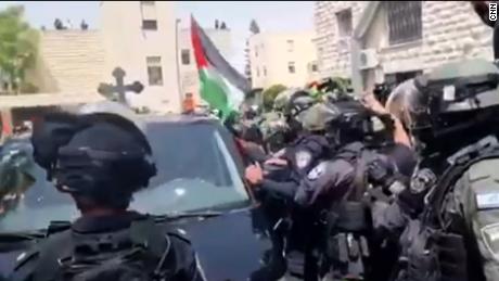 Israeli forces removed Palestinian flags from a hearse carrying the coffin of Shireen Abu Akleh as it moved through the streets of Jerusalem Friday.