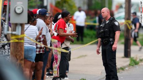 Police speak to bystanders after the shooting at a convenience store May 14, 2022 in Buffalo, New York.