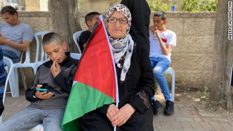 Nafisa Khwais, 63, senta-se do lado de fora da casa de Shireen Abu Akleh em Ramallah, onde os enlutados se reúnem. 
