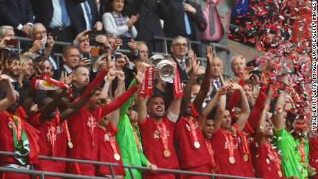 Jordan Henderson lifts the FA Cup after Liverpool&#39;s shootout win over Chelsea.
