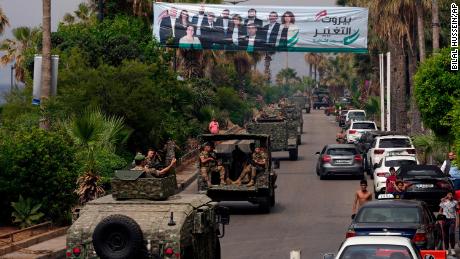 Libānas armijas automašīnas 14. maijā Beirūtā, Libānā, pabrauc garām reklāmas stendam, kurā attēloti parlamenta vēlēšanu kandidāti.
