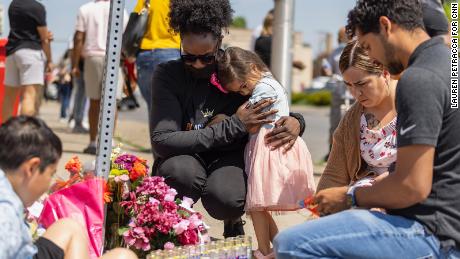 Mourners gather Sunday outside the Tops Friendly Market.