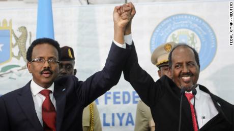Somalia&#39;s newly elected president Hassan Sheikh Mohamud (right) holds hands with incumbent president Mohamed Abdullahi Mohamed (left) after winning the elections in Mogadishu, Somalia May 16, 2022.
