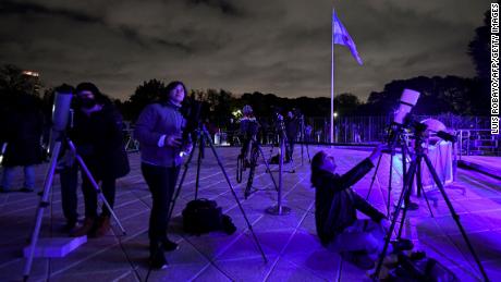 Хората в Буенос Айрес гледат луната през телескопи рано в понеделник по време на пълно лунно затъмнение. 
