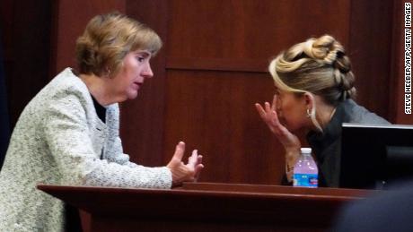 Amber Heard, Pazartesi günü mahkeme salonunda avukatı Elaine Bredehoft ile konuşuyor.