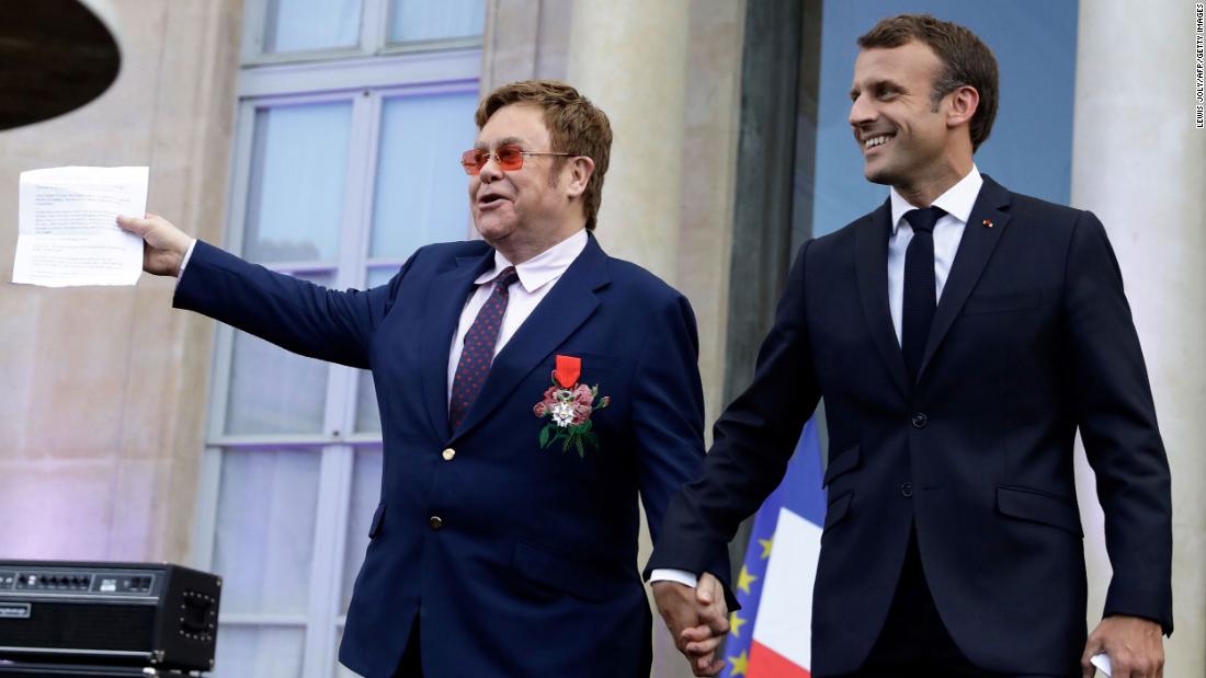John and French President Emmanuel Macron arrive to speak to a crowd in Paris in June 2019. John was being honored with France&#39;s highest civilian award.