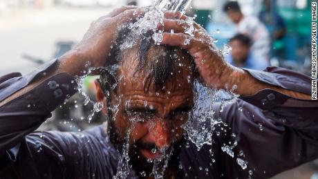 A man uses a water pipe to cool off in Karachi, Pakistan, during a heatwave.