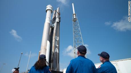 NASA astronautai Sonny Williams, kairėje, Barry  Butch & quot;  Willmore'as, centre, ir Mike'as Finky, dešinėje, žiūri United Launch Alliance Atlas V raketą su Boeing transporto priemone.  „SpaceX“ „CST-100 Starliner“ nuo vertikalios integracijos įrenginio iki paleidimo aikštelės 41 kosminio paleidimo komplekse prieš „Orbital Flight Test 2“ (OFT-2) misiją, trečiadienį, 2022 m. gegužės 18 d. Kanaveralo kyšulio kosminėje stotyje Floridoje. 