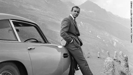 นักแสดง Sean Connery สวมบทบาทเป็น James Bond ถัดจาก Aston Martin DB5 ในฉากจาก 'Goldfinger' ในปี พ.ศ. 2507 