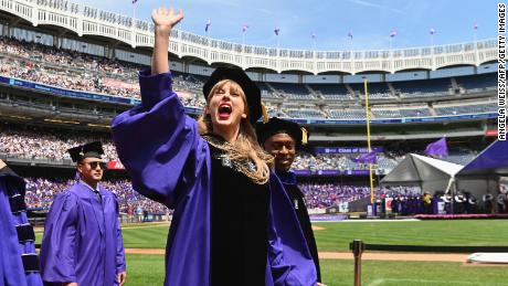 Taylor Swift waves at graduating students during New York University&#39;s commencement ceremony for the class of 2022.