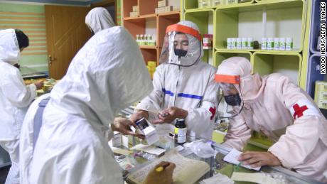 Members of the North Korean military&#39;s medical section (back) work to distribute medicine to citizens (front) at a pharmacy in Pyongyang on May 18, 2022, to contain the spread of COVID-19 infections. North Korea reported what it claims is its first COVID-19 outbreak on May 12. (Photo by Kyodo News via Getty Images)