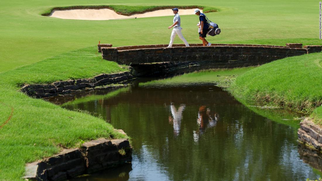 Rory McIlroy and caddie Harry Diamond walk over a bridge on the third hole during a practice round prior to the start of the 2022 PGA Championship.