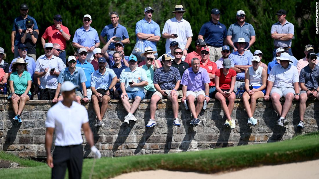 Fans watch as Tiger Woods prepares to play a shot on the sixth hole.
