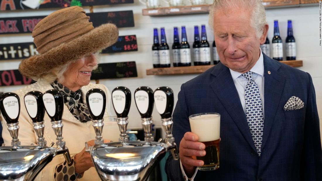 Camilla looks on as Charles reacts to a bad pour of beer he made at a brewery in St. John&#39;s, Newfoundland and Labrador, in May 2022. They were on a three-day Canadian tour.