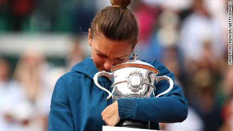 Simona Halep hugs the trophy as she celebrates after winning the women's singles final against Sloane Stephens in the French Open final on June 9, 2018 in Paris, France.