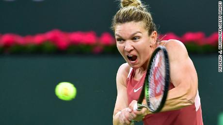 Simona Halep hits a backhand return to Iga Swiatek of Poland in their WTA semifinal match at the Indian Wells tennis tournament on March 18, 2022.