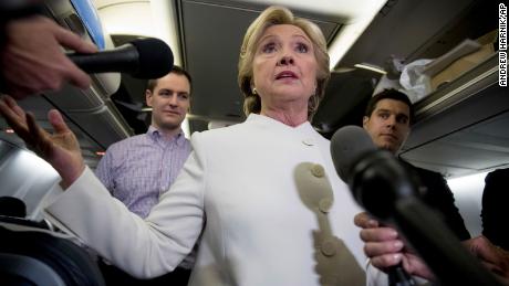 Democratic presidential candidate Hillary Clinton, center, accompanied by Campaign Manager Robby Mook, left, and traveling press secretary Nick Merrill, right, speaks with members of the media aboard her campaign plane at McCarran International Airport in Las Vegas, Wednesday, Oct. 19, 2016, following the third presidential debate. (AP Photo/Andrew Harnik)