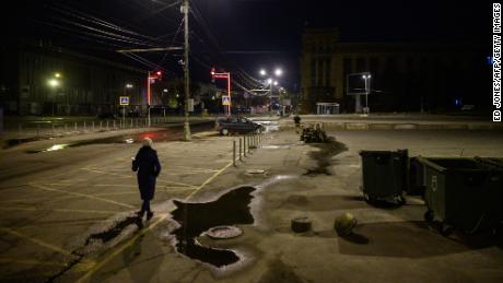 A pedestrian walks along a street past anti-tank obstacles shortly before a curfew in Dnipro on April 14, 2022, amid Russia&#39;s military invasion launched on Ukraine. 