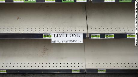 A sign in front of empty shelves notifies customers that they are allowed only one container of baby formula at a store in Utah this month. 