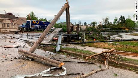Tiang telepon dan kabel listrik tumbang pada hari Jumat menyusul badai di daerah Gaylord di Michigan.