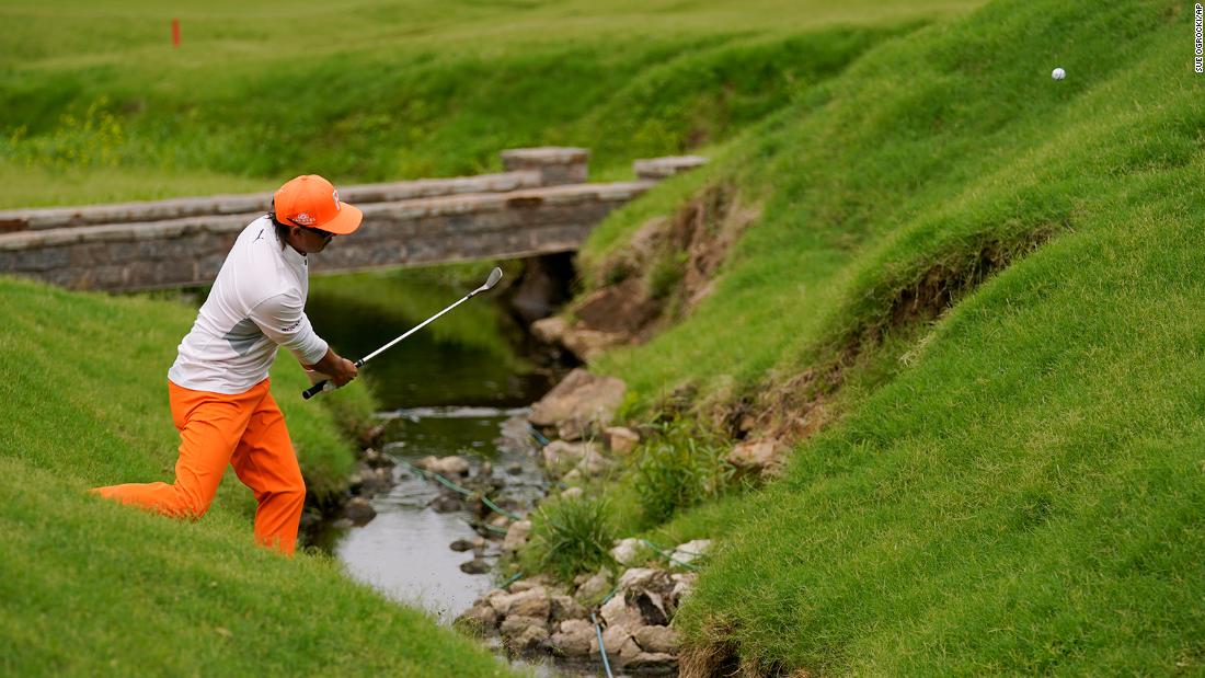 Rickie Fowler hits from the hazard on the 17th hole.