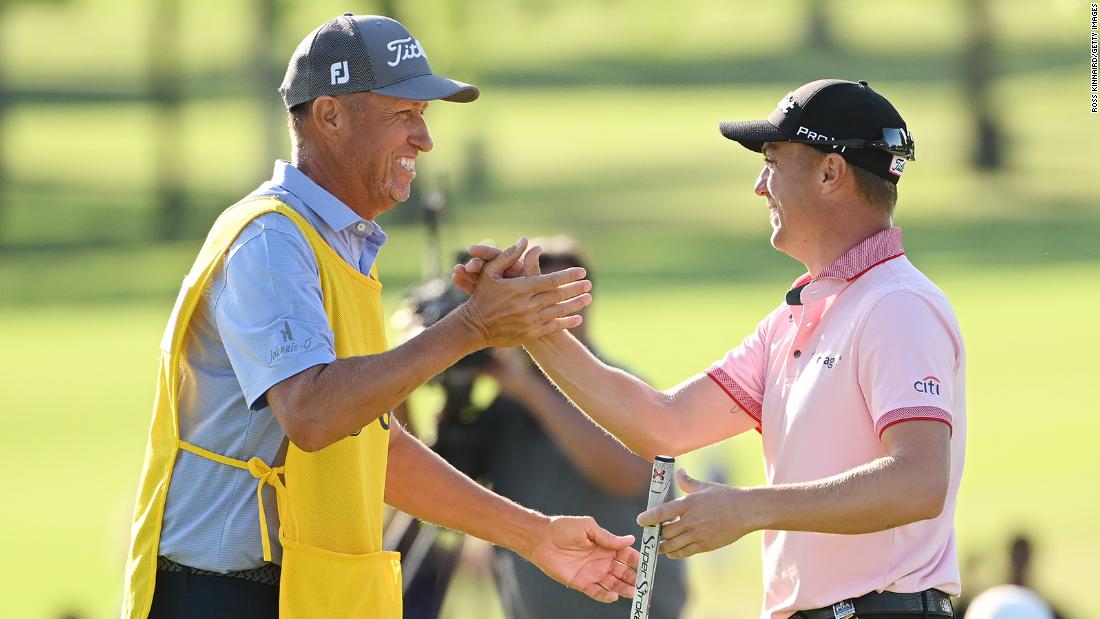 Justin Thomas reacts to his winning putt on the 18th hole with caddie Jim &quot;Bones&quot; Mackay.