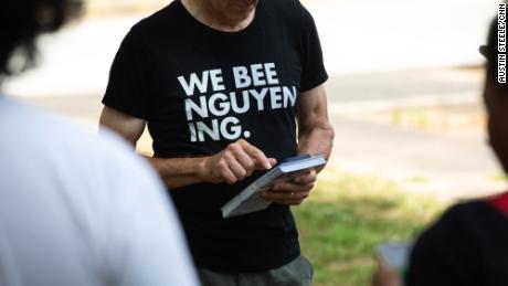 Un bénévole porte une chemise de campagne.  Nguyen se prononce 