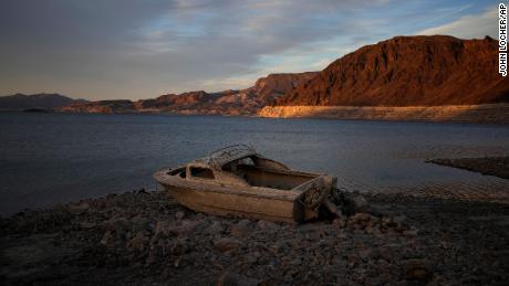 A formerly submerged boat sits high and dry along the shoreline of Lake Mead.