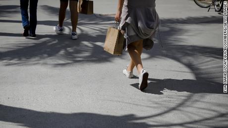 A pedestrian carries a shopping bag while walking in Miami, Florida, U.S., on Saturday, Oct. 23, 2021. 