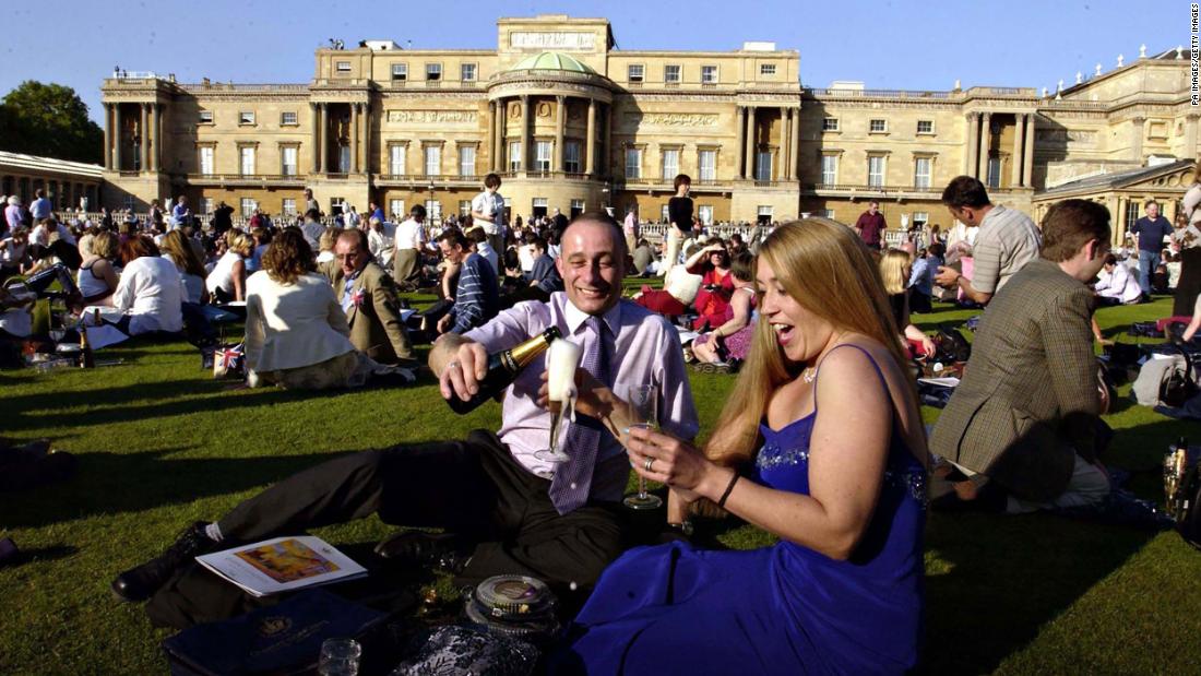 Craig Metcalf and Jayne Wood, both from Brighouse, Yorkshire, join thousands of others in the grounds of Buckingham Palace in London for the Prom at the Palace, a classical concert, on the first evening of the Golden Jubilee celebratory weekend in 2002.