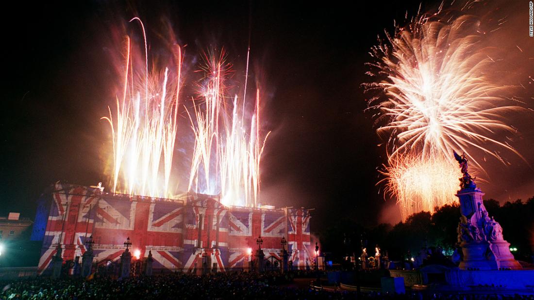 Buckingham Palace is emblazoned with images of the Union Jack flag while fireworks light up the sky after the concert. 