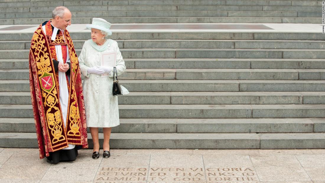 Accompanied by the Dean of St. Paul&#39;s, David Ison, the Queen views an inscription at the foot of the steps of the cathedral commemorating Queen Victoria&#39;s 60th anniversary on the throne.